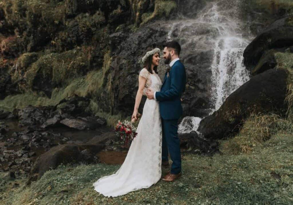 A wedding couple by an Icelandic waterfall