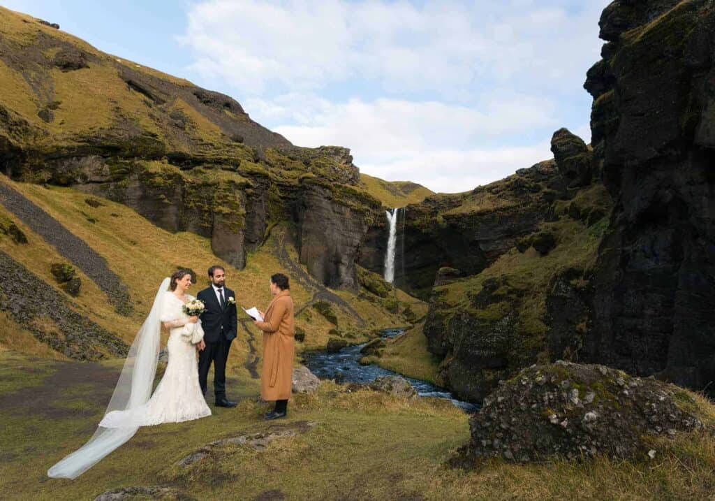 A couple getting married in Icelandic summer time by a waterfall.