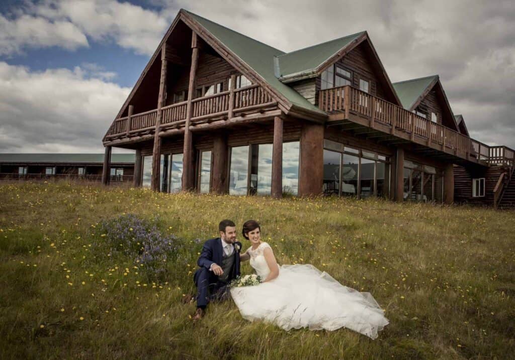 A wedding couple posing in front of Hotel Rangá, wedding photoshoot in Icelandic summer.