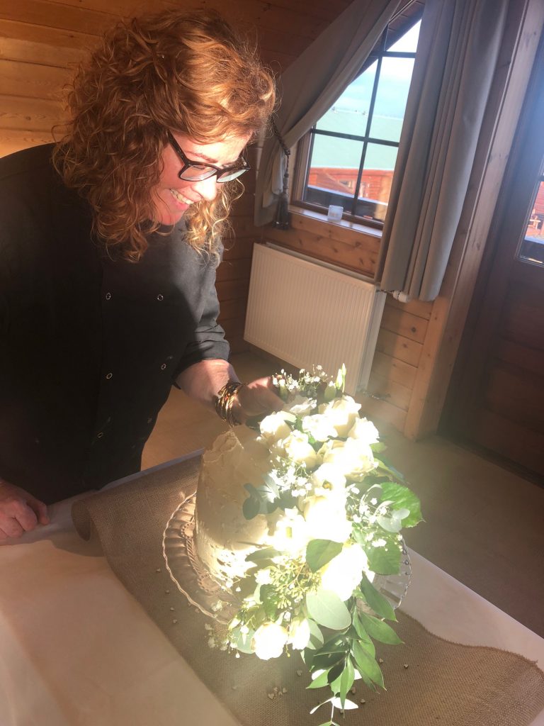 A wedding decorator working on a cake