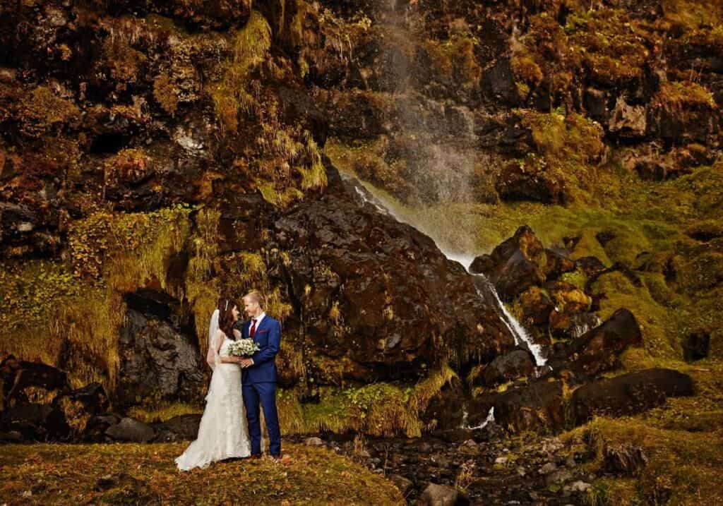 A wedding photoshoot by an Icelandic waterfall.