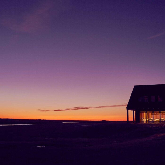 A sunset turns the sky orange, pink and purple outside Hotel Rangá in south Iceland.
