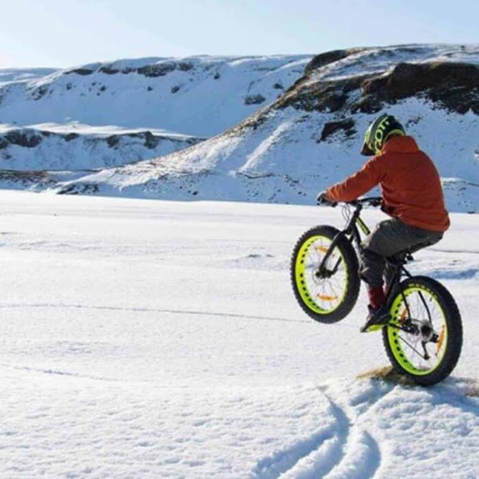 Man rides fat bike on a snowy field in south Iceland.