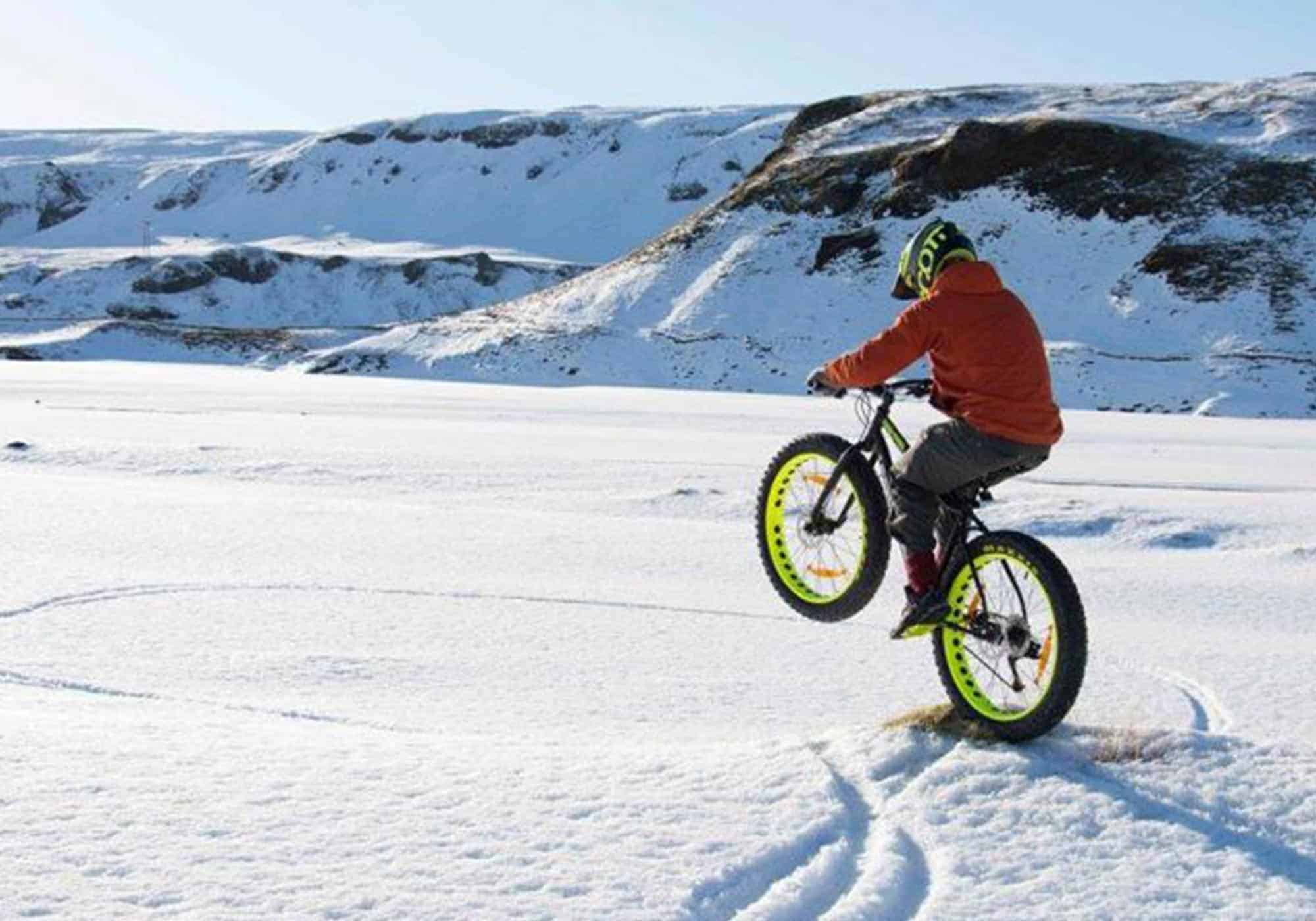 Man rides fat bike on a snowy field in south Iceland.