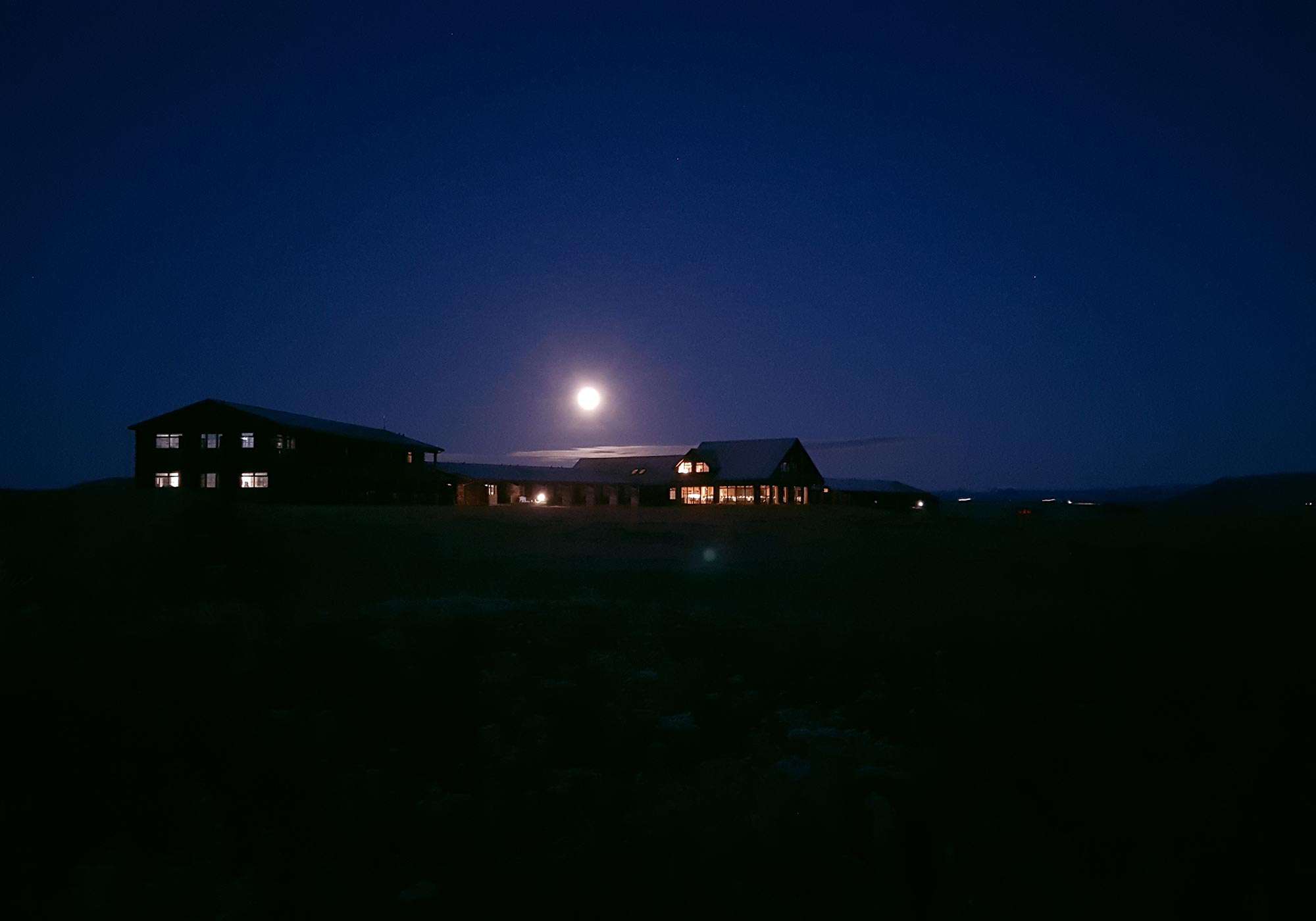 Exterior of Hotel Rangá at nighttime underneath the moon.