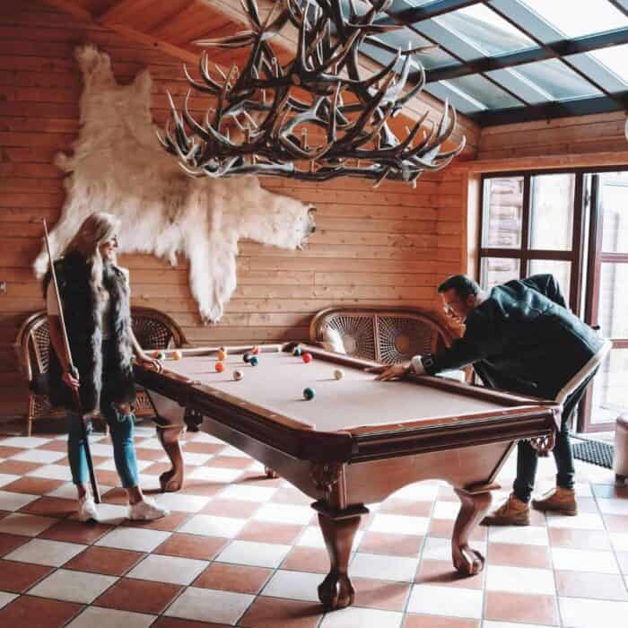 Man and woman play a game of pool in Hotel Rangá's game room.