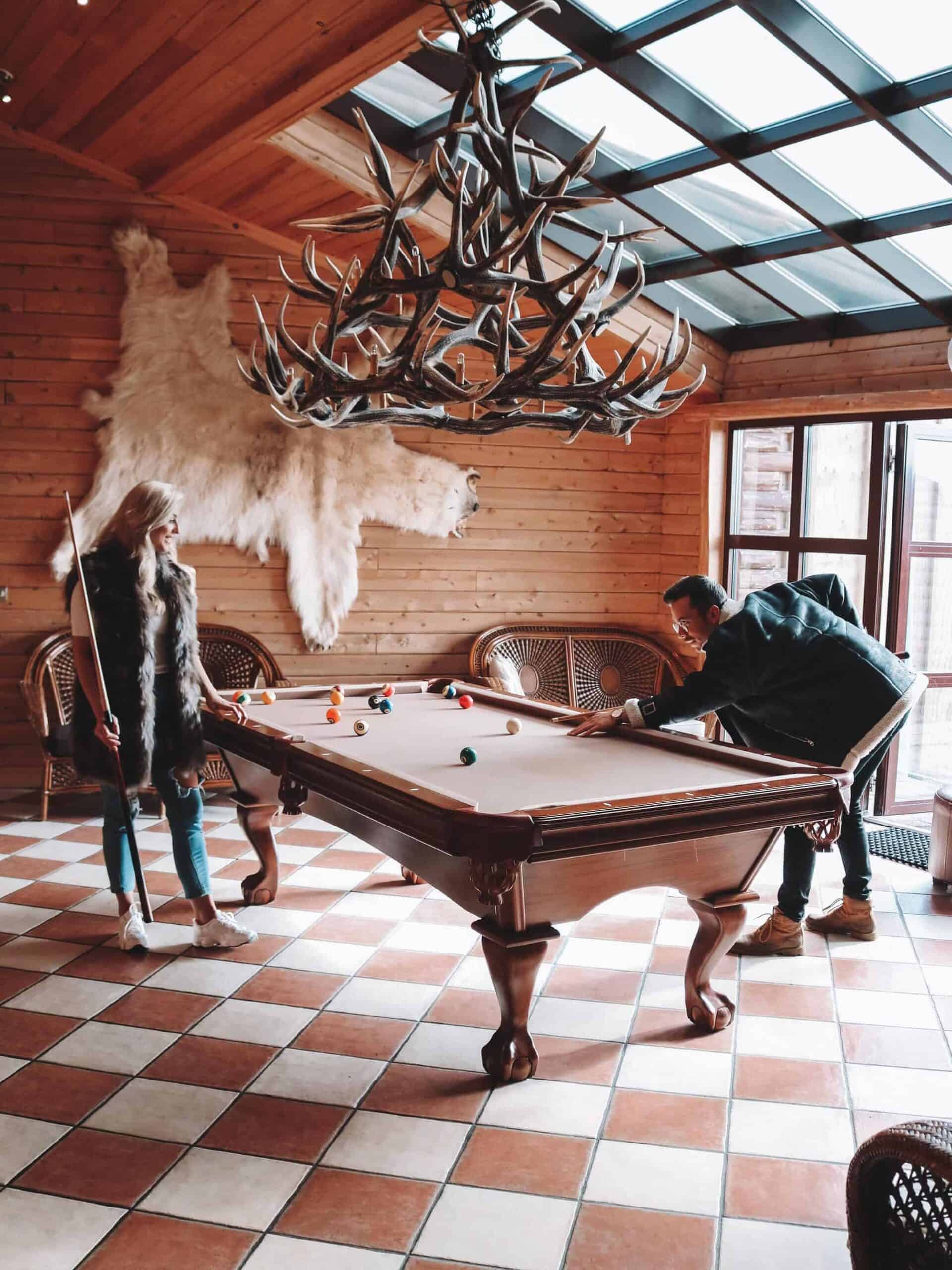 Man and woman play a game of pool in Hotel Rangá's game room.
