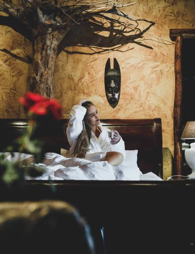 A woman enjoying a the morning coffee in Hotel Rangá's Africa Suite. 