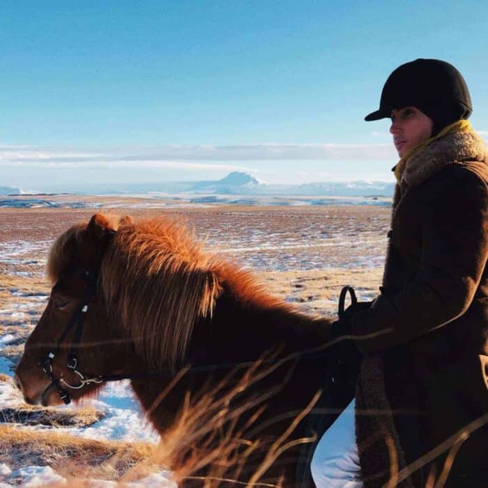 Lucas Raven rides an Icelandic horse across fields in south Iceland.