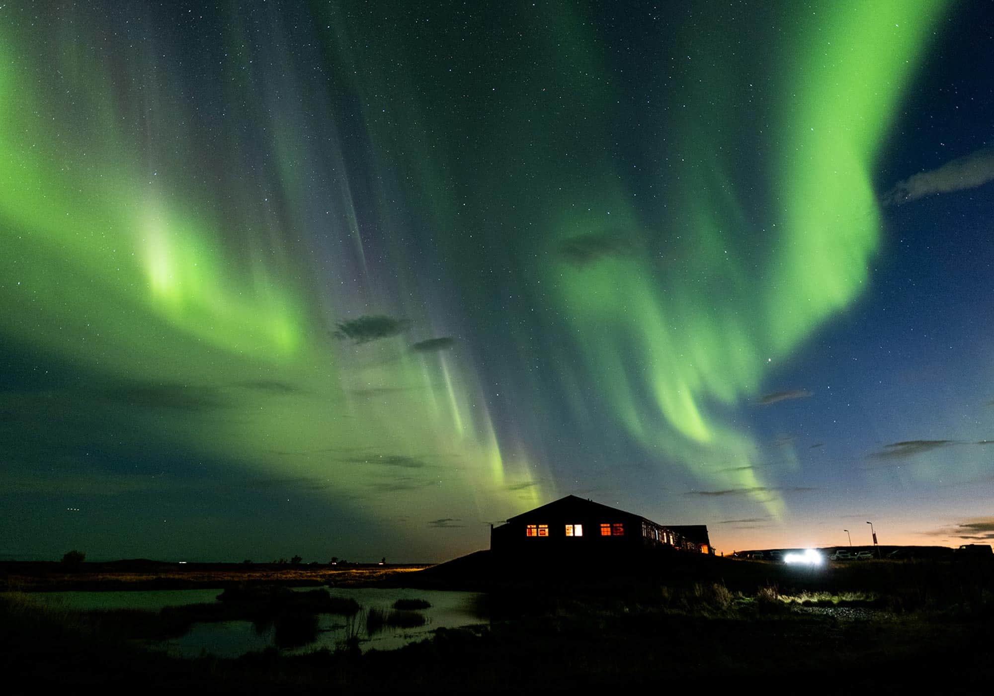 Green northern lights in a starry night sky above the Hotel Rangá Observatory.