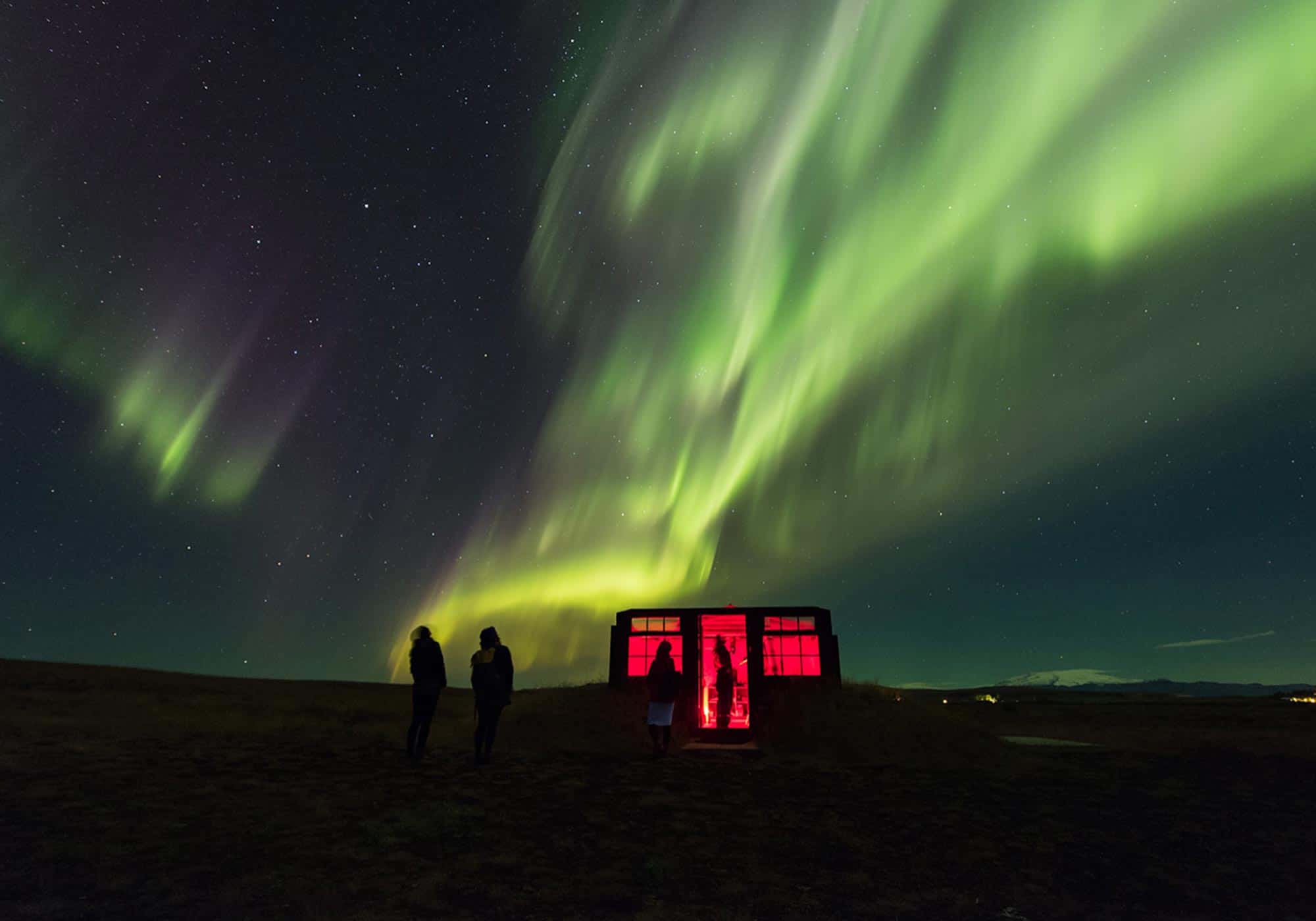 Green and pink northern lights above the Hotel Rangá Observatory.