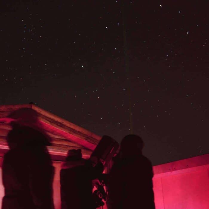 Guests stand in the Rangá Observatory and look at the starry night sky.