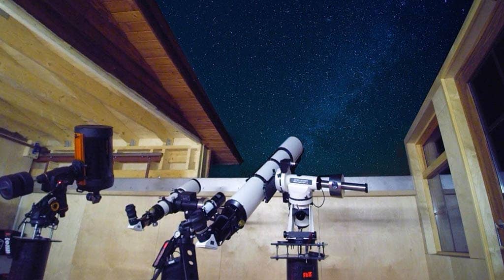 Two high-powered telescopes pointed at the starry night sky in the Rangá Observatory.