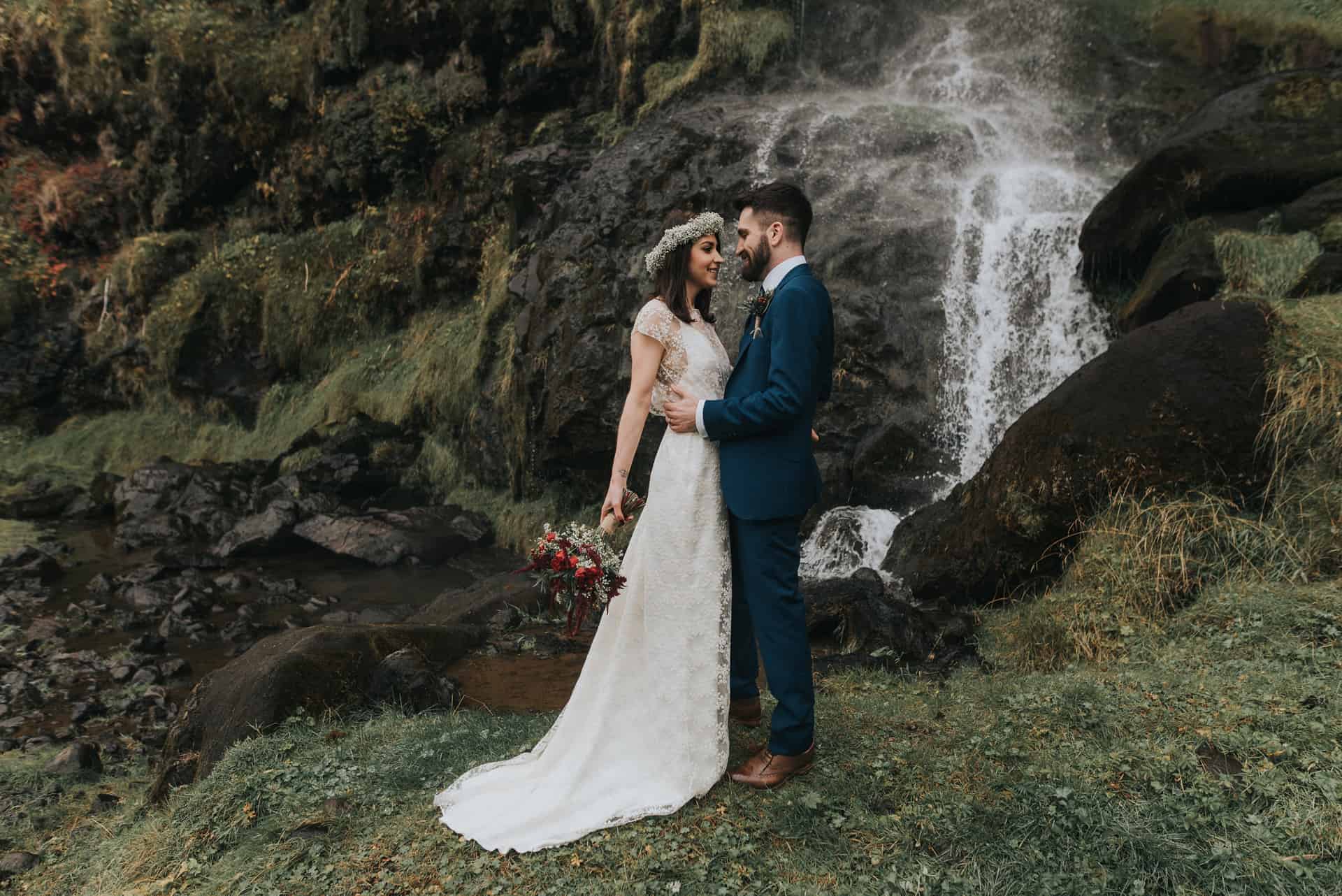 Wedding couple beside Icelandic waterfall 