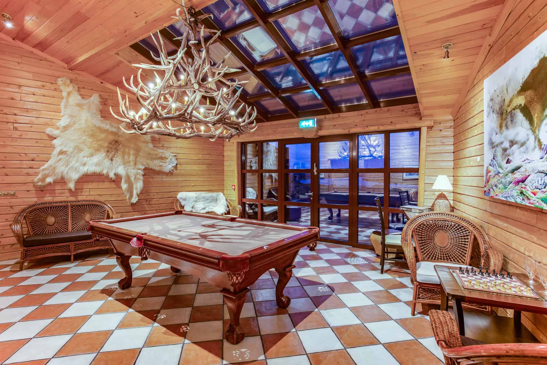 Hotel Rangá's game room includes a pool table, a polar bear skin on the wall, an antler chandelier, a chess board and more local art.