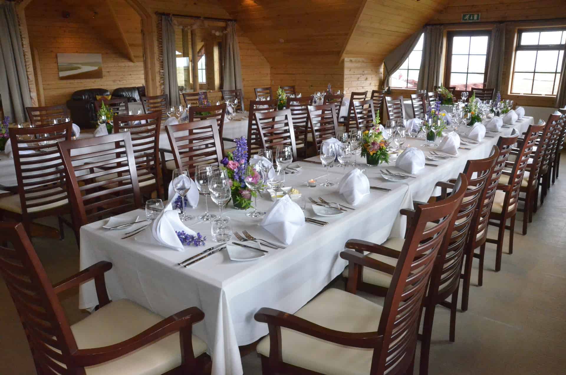 Hotel Rangá's River Hall set up for a wedding with two long tables and flower arrangements.