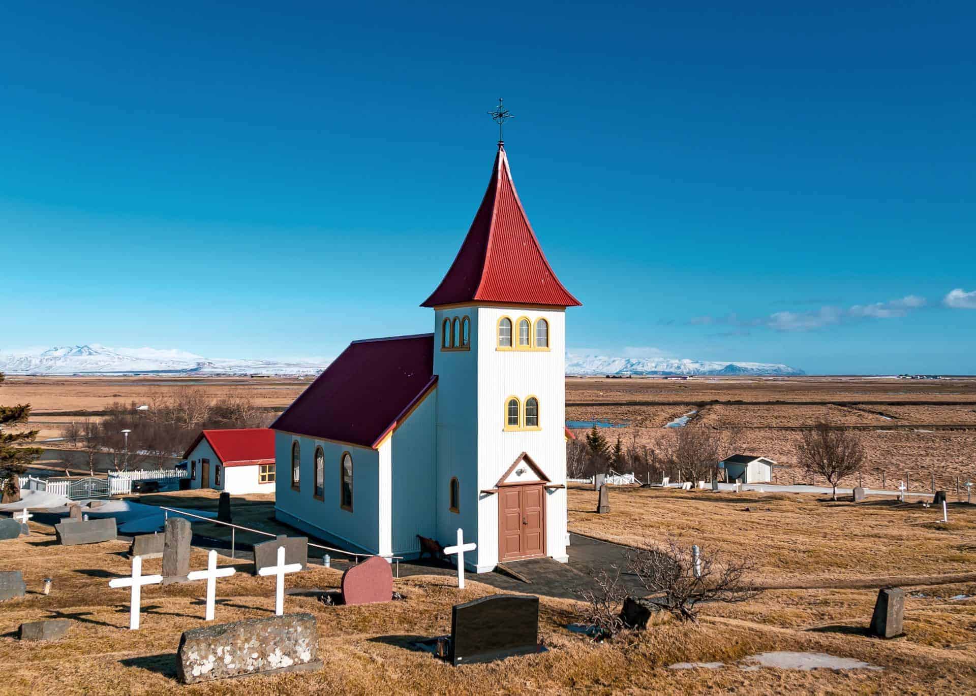 The Oddakirkja church - white with a red roof - is located just beside a small cemetery.
