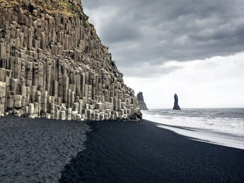 Columnar basalt borders the black sand beach at Reynisfjara.
