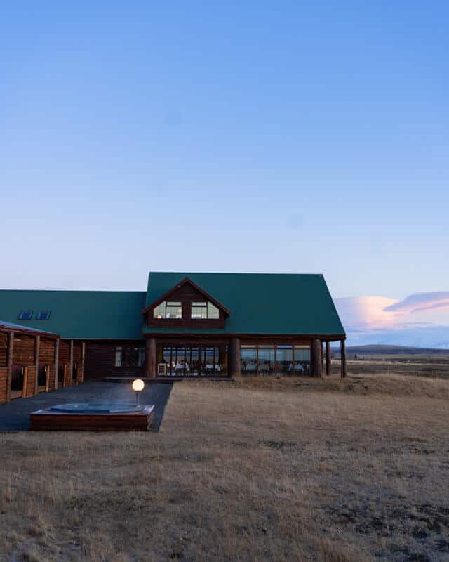 Exterior of Hotel Rangá at dusk with outdoor geothermal hot tub in foreground.