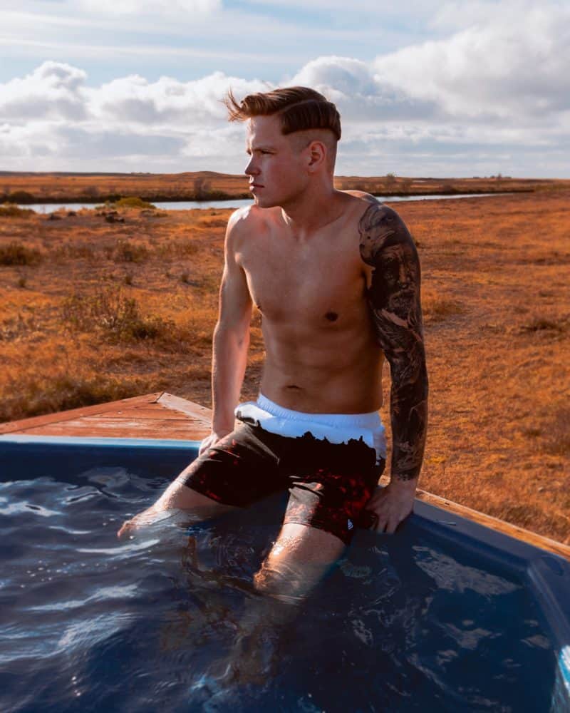 Man wearing Secret of Iceland swim trunks in a Hotel Rangá geothermal hot tub.