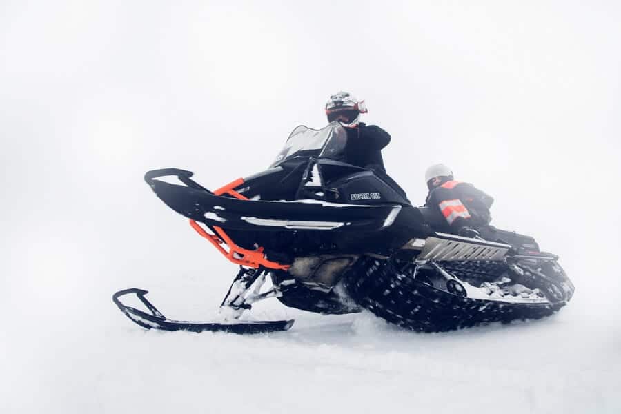 Man drives snowmobile across glacier in south Iceland.