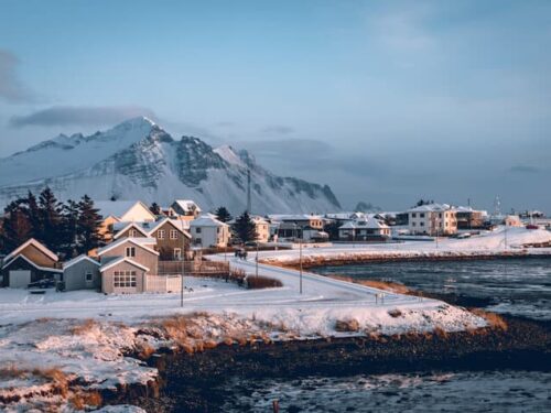 Snow-covered houses and far off mountains in the small Icelandic village of Höfn.