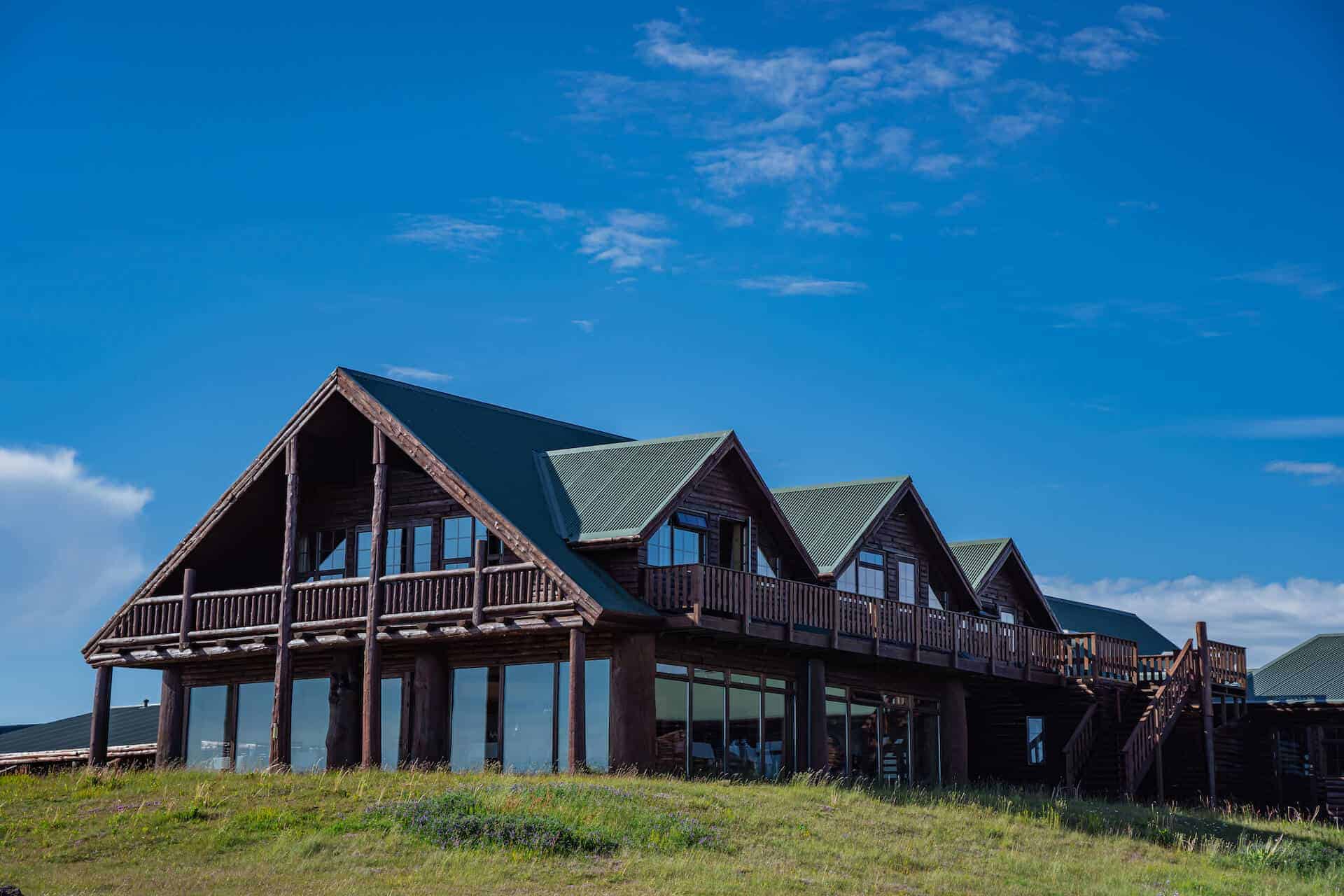 Exterior of Hotel Rangá on a bright summer day with blue skies and green grass.