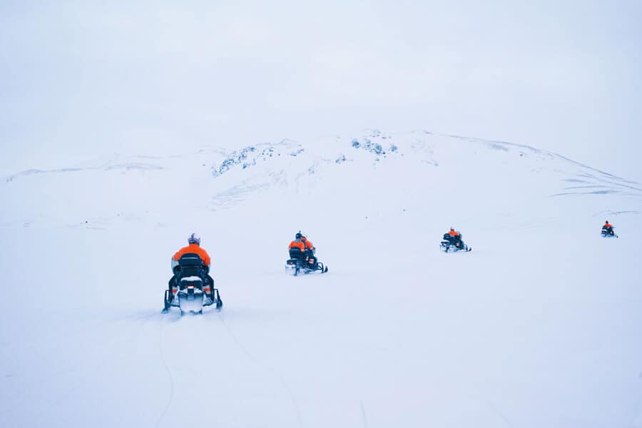 Four snowmobiles drive across the Eyjafjallajökull glacier in south Iceland.
