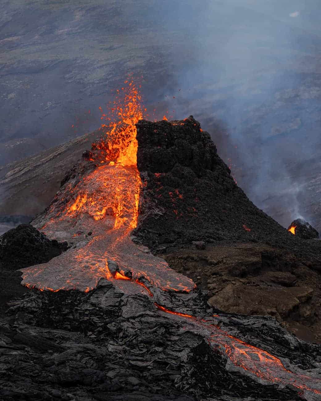 Fagradalsfjall volcano erupting with lava pouring out of the main crater.