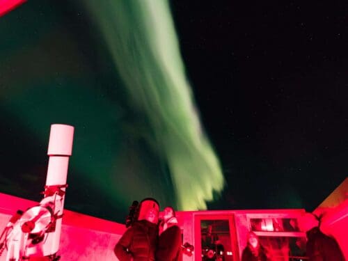 A band of bright green northern lights above the Rangá Observatory that houses two high-tech telescopes.
