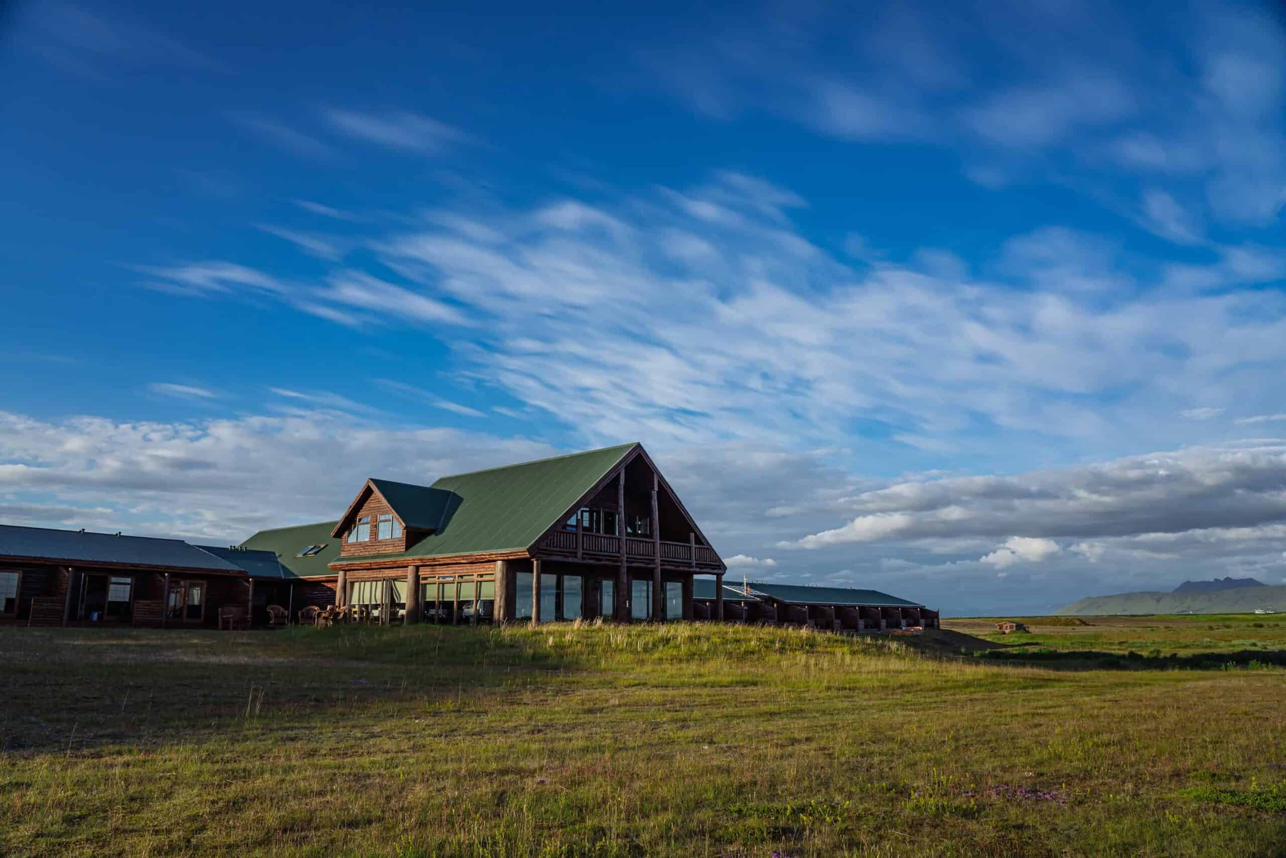 Exterior of Hotel Rangá on a summer day with blue skies overhead and green grass in the foreground.