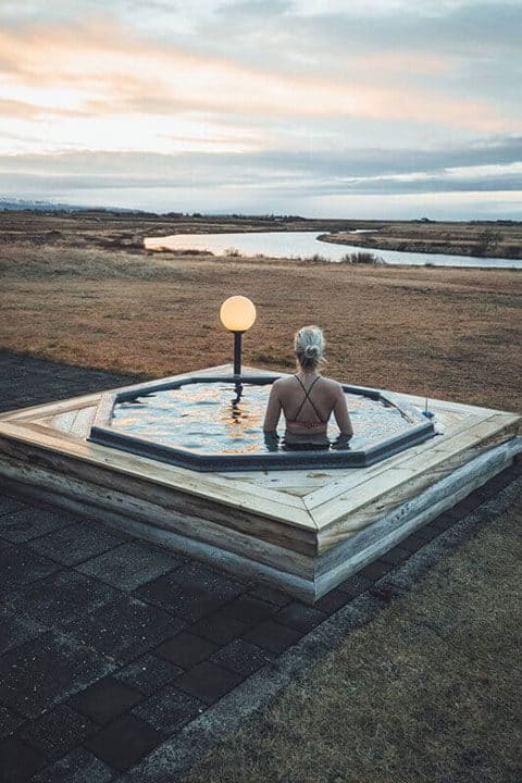Woman sits in a geothermal hot tub at Hotel Rangá with views of the Rangá River.