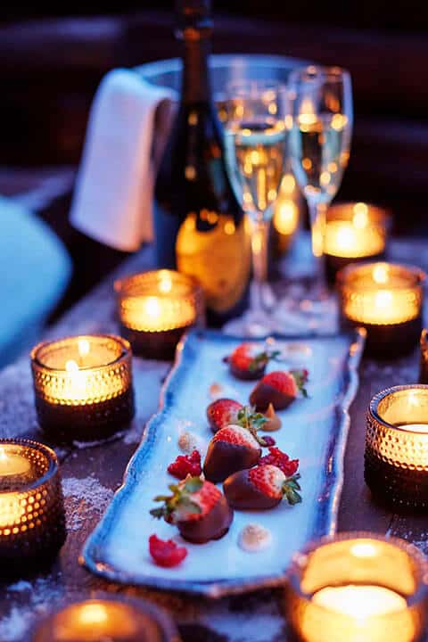 Candles surrounding a plate of chocolate covered strawberries and two glasses of champagne at Hotel Rangá.