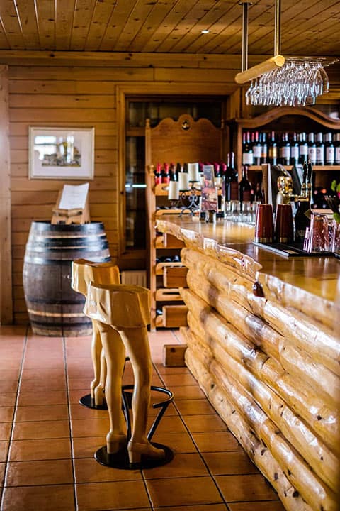 The Rangá Bar decorated with rustic logs and featuring hand carved bar stools.