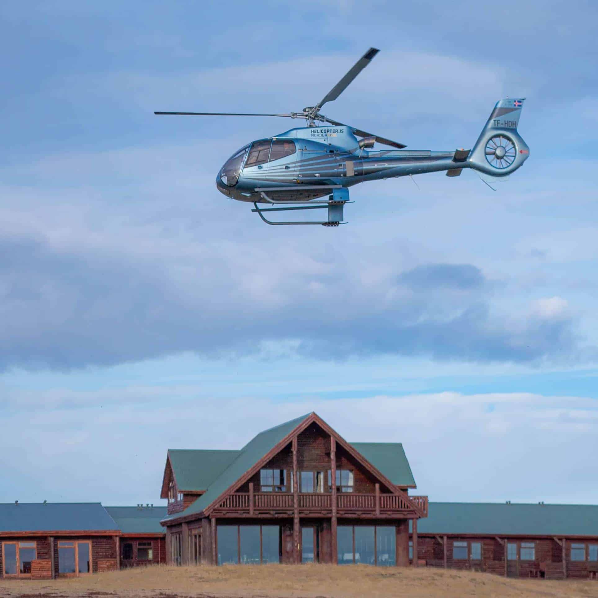 A helicopter flies above Hotel Rangá luxury hotel in south Iceland.