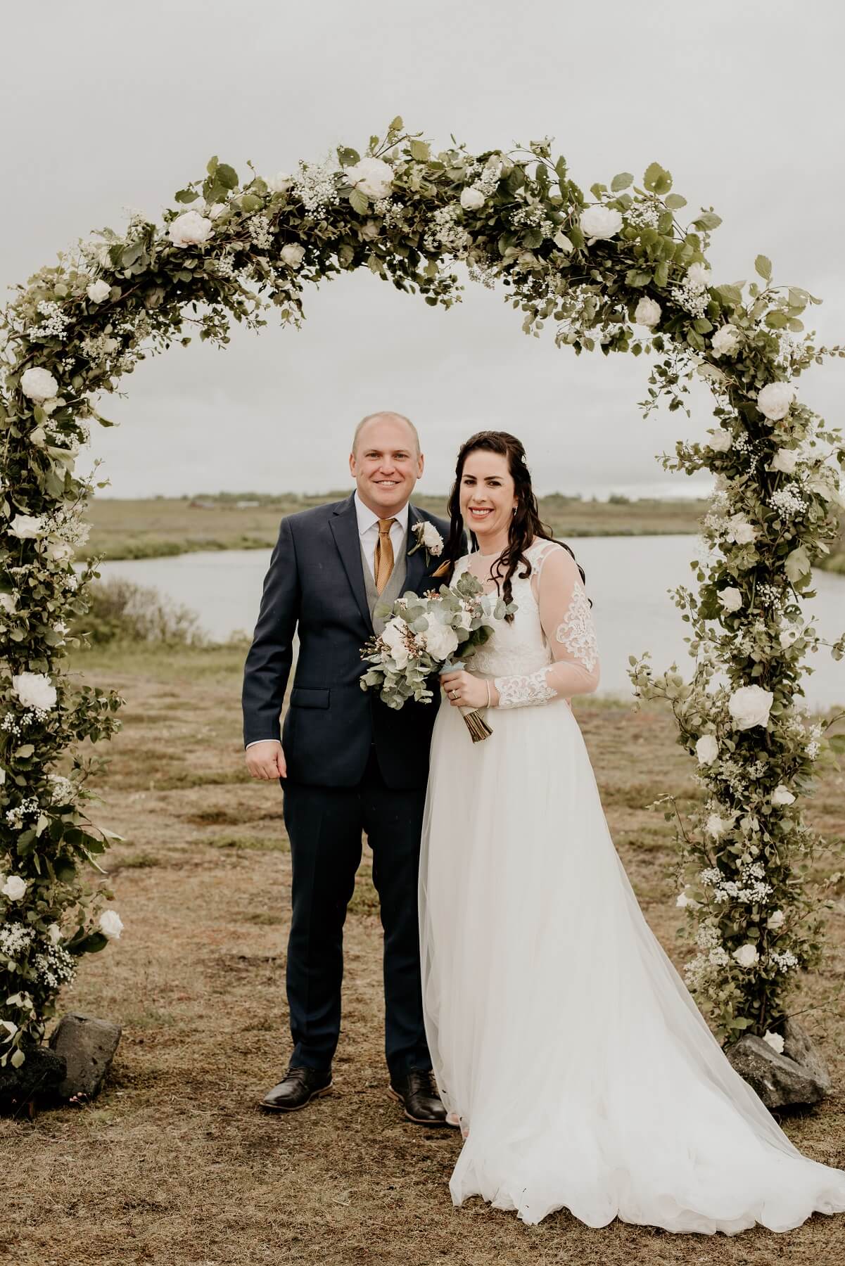 Wedding couple stand underneath a floral archway at Hotel Rangá luxury hotel.