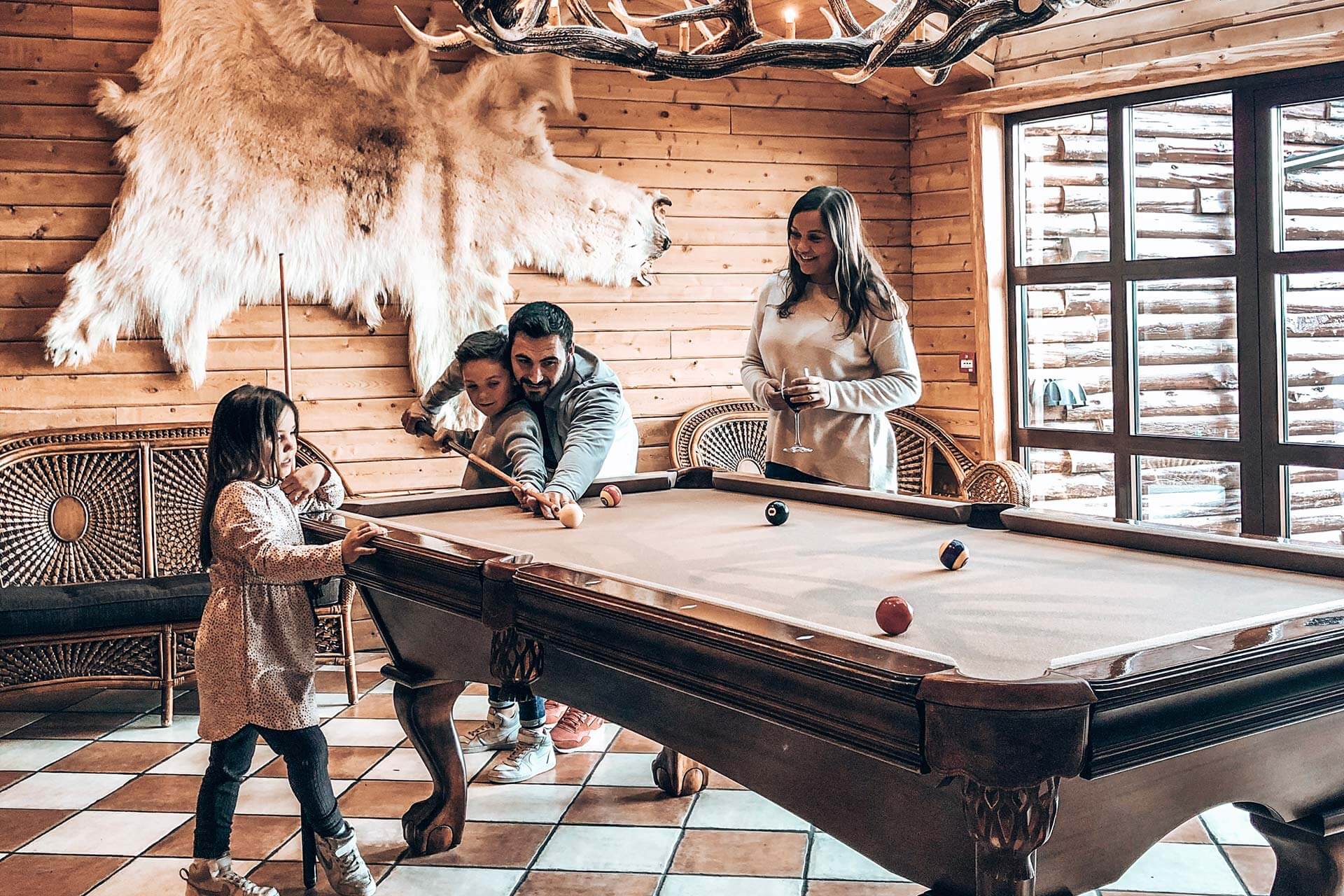 Parents and their two children play pool in Hotel Rangá's game room.