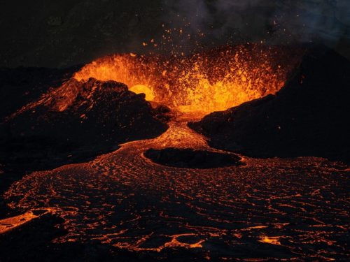Red and orange lava bursts from the earth at Iceland's Meradalir volcano.