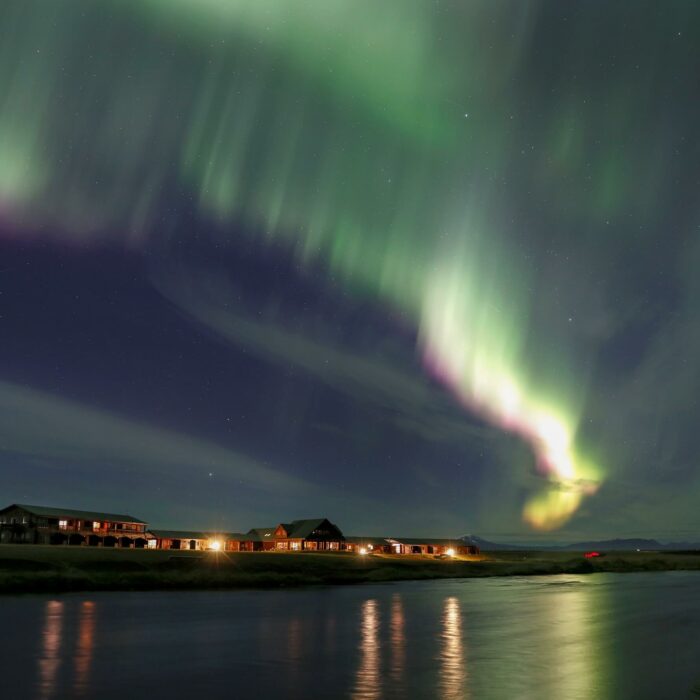 Green and purple northern lights visible over Hotel Rangá and the Rangá River.