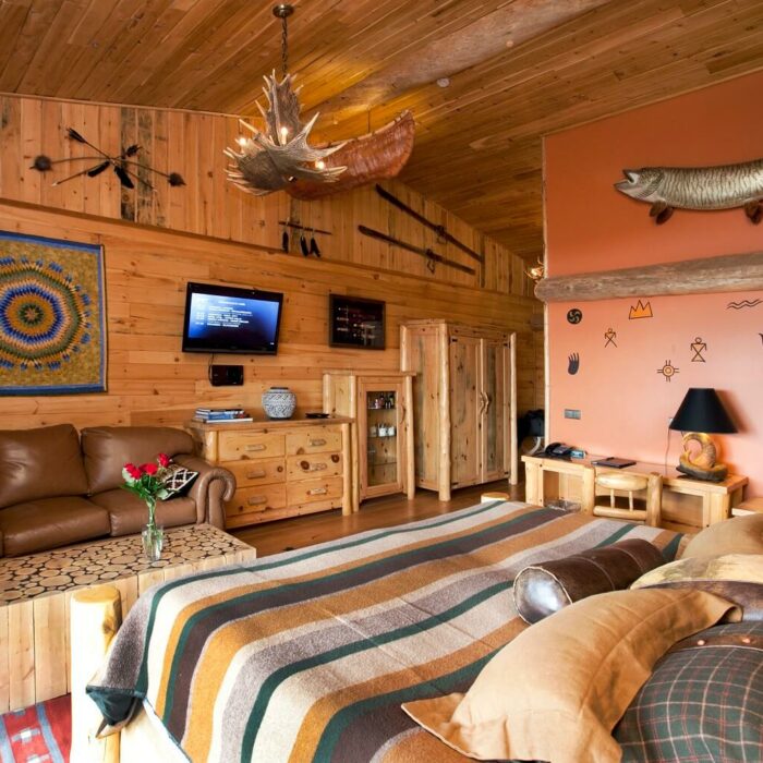 Hotel Rangá's North America Suite decorated with a bison head, antler chandelier, fish wall decoration, Native American blanket and more.