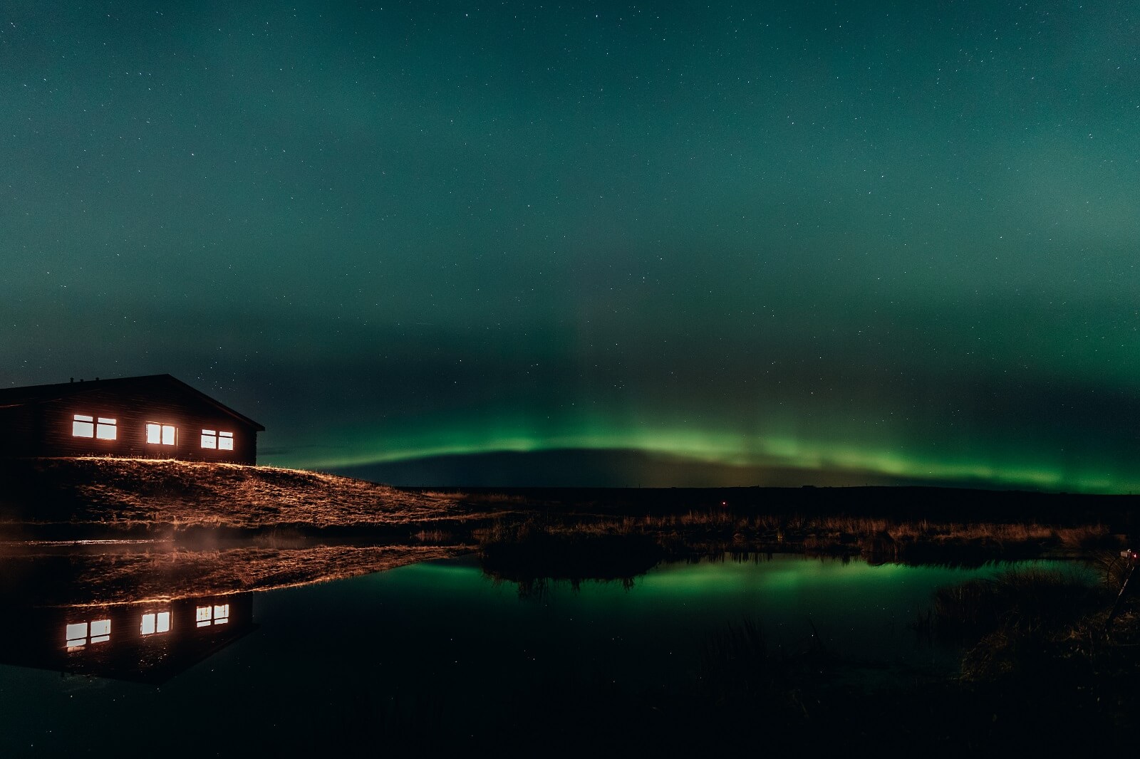 A band of northern lights stretches out beside Hotel Rangá in south Iceland.