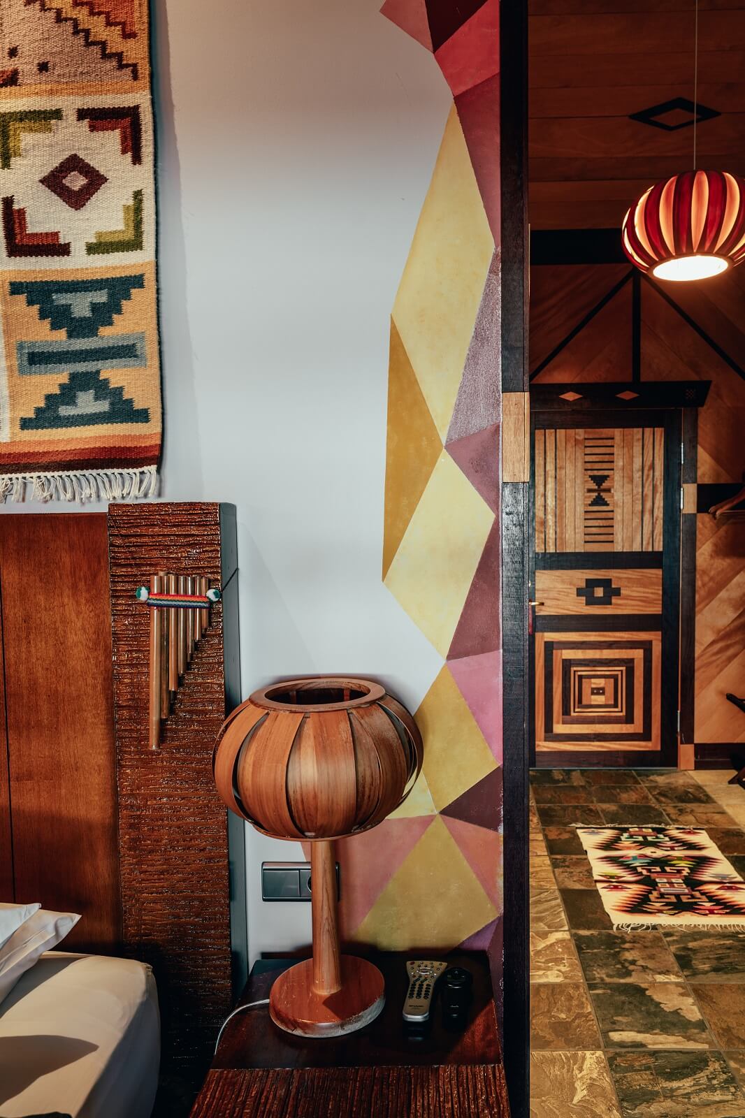 Hotel Rangá's South America Suite featuring wooden lamps from Uruguay and a geometric wall mural. 