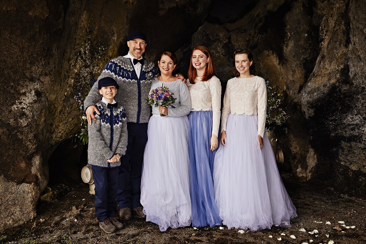 Stacey, Jerry and their three children wear wedding clothes and pose in the small cave Gapí in south Iceland.