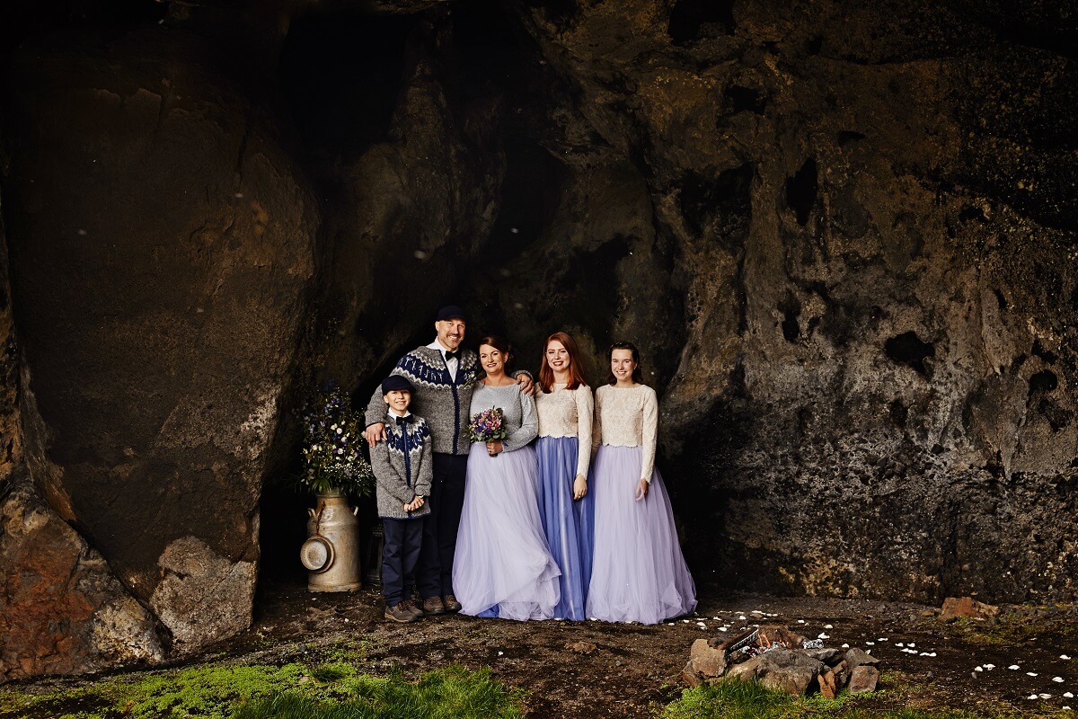 Stacey, Jerry and their three children stand in their wedding clothes in the small cave known as Gapí in south Iceland.