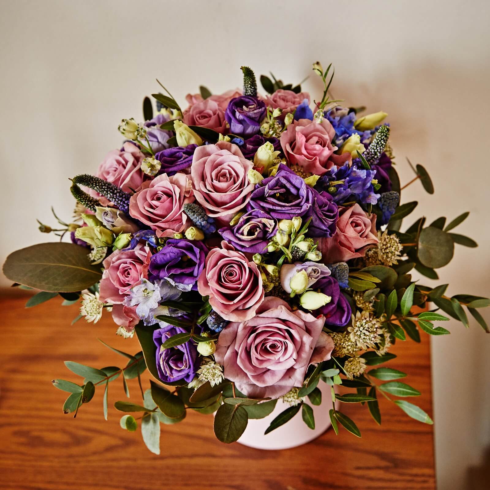 Wedding bouquet at Hotel Rangá filled with pink roses, purple blooms, green leaves and white accent flowers.