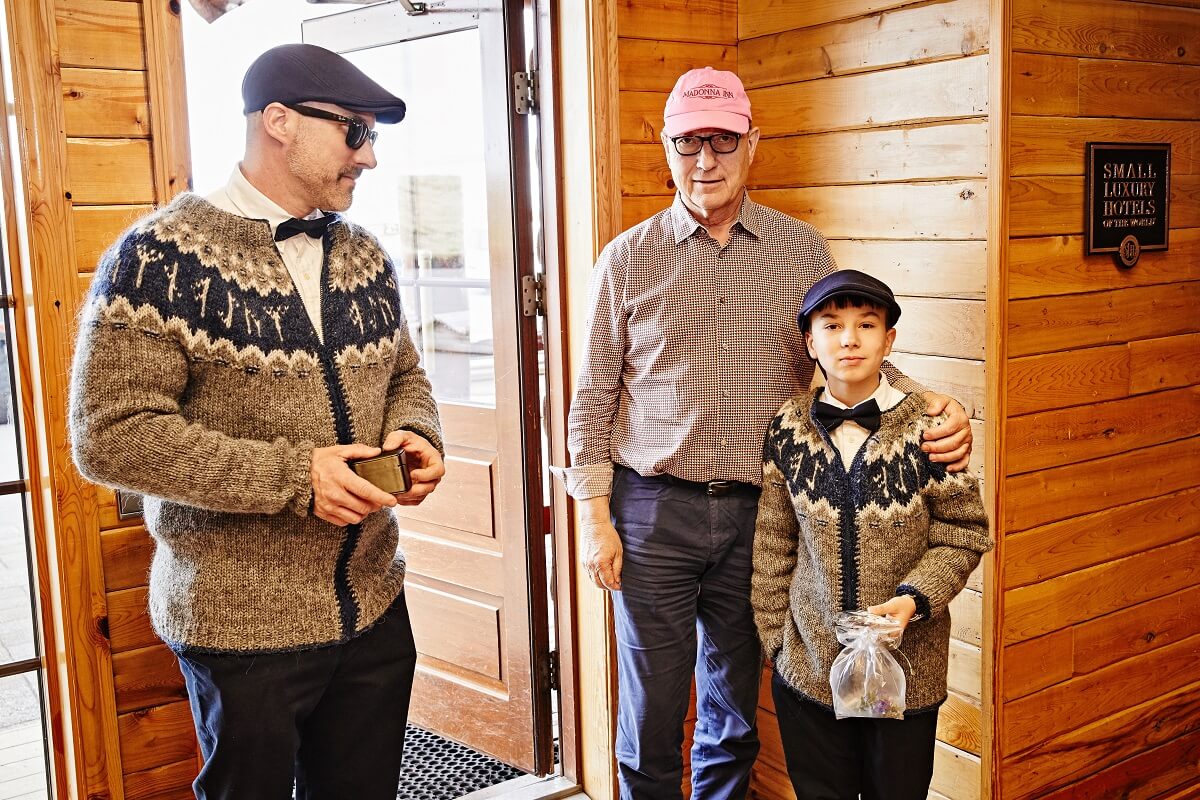Jerry Stover and his son wear traditional Icelandic lopapeysa as they pose with hotelier Friðrik Pálsson in the Hotel Rangá lobby.