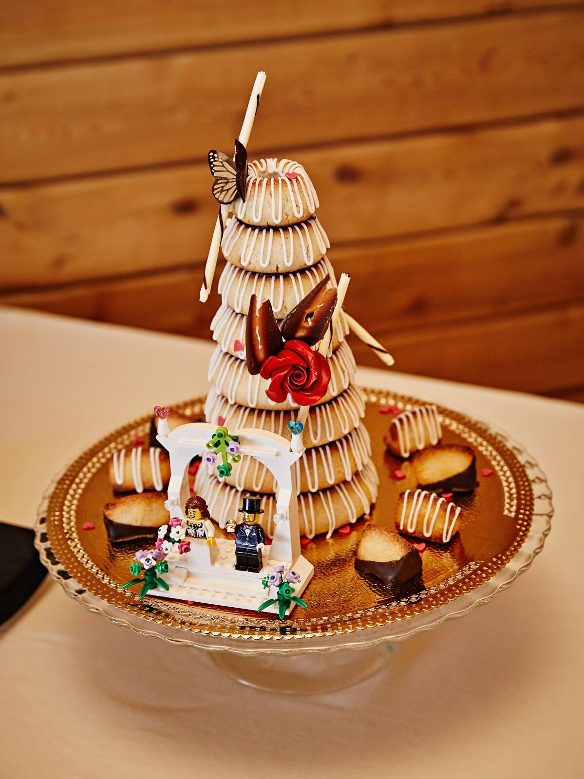Icelandic kransakaka wedding cake on gold platter with small Lego bride and groom figures.
