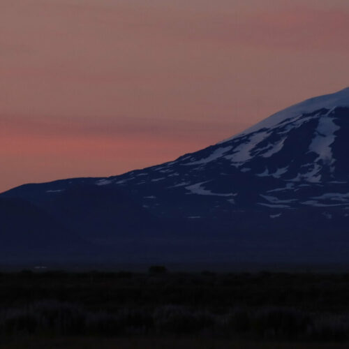 The snow-covered volcano, Hekla, underneath Iceland's midnight sun.