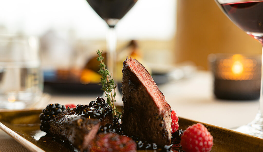 Icelandic lamb surrounded by fresh berries and a thyme sprig at the Hotel Rangá Restaurant.