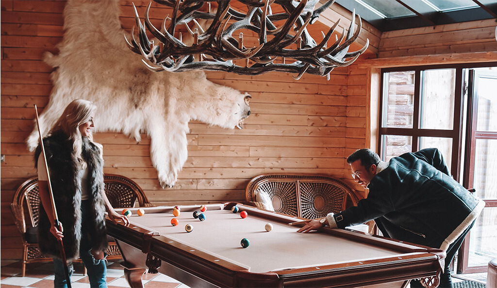Man and woman play pool in Hotel Rangá's game room.
